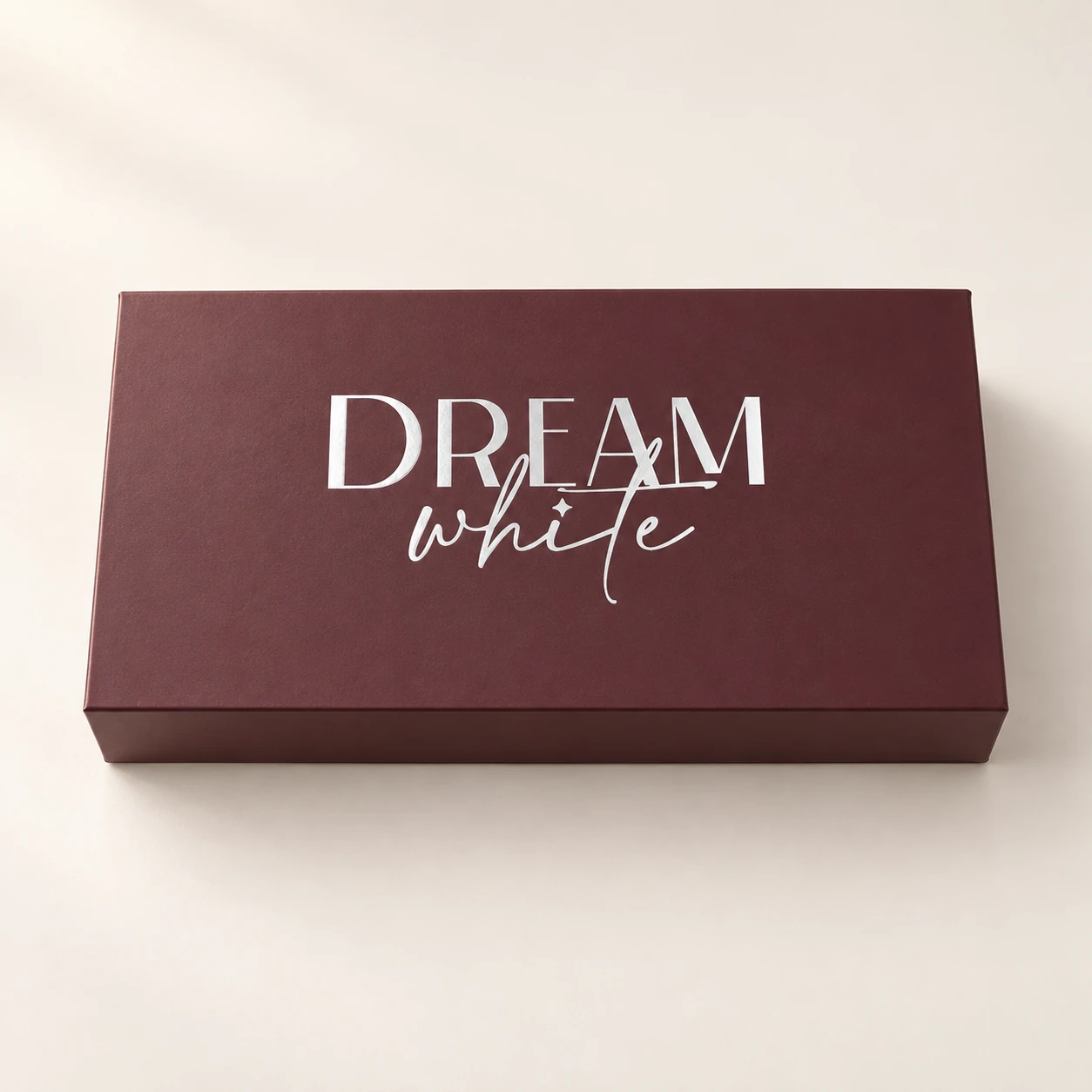 Bordeauxfarbene Dreamwhite-Verpackung mit silbernem Logo