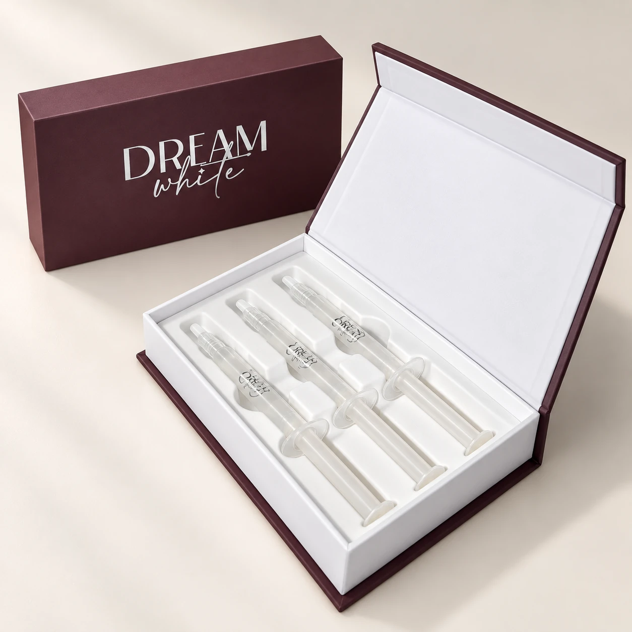 Geöffnete Dreamwhite-Box mit drei Gel-Spritzen in einer weißen Einlage, dahinter die geschlossene Verpackung