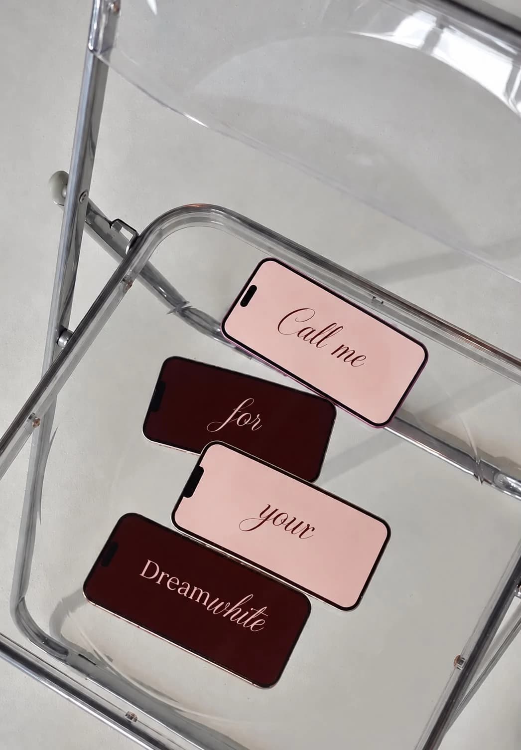 Vier Smartphones mit dem Schriftzug Call me for your Dreamwhite auf einem transparenten Stuhl